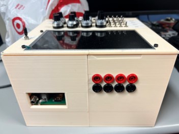 Image of rear of RTD test set, cream box with 4 red and 4 black connectors, and a power connectore.